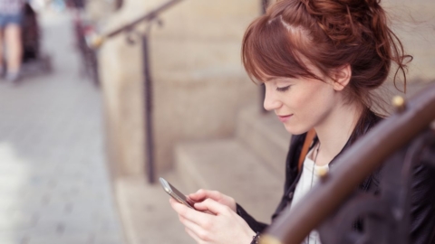 Frau mit Blick auf das Handy