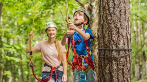 Frau und Kind auf einer Plattform im Kletterwald